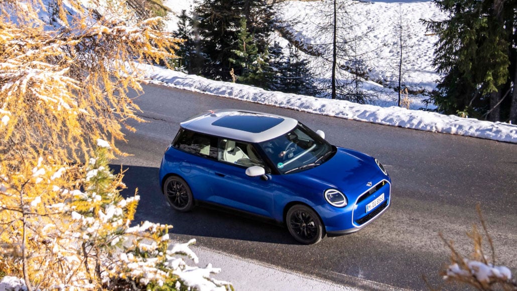 Eine blaue MINI Cooper SE auf winterliche Fahrbahn.